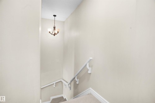 Stairs with baseboards and a chandelier - 1442 33A Street Nw, Edmonton, AB - Indoor