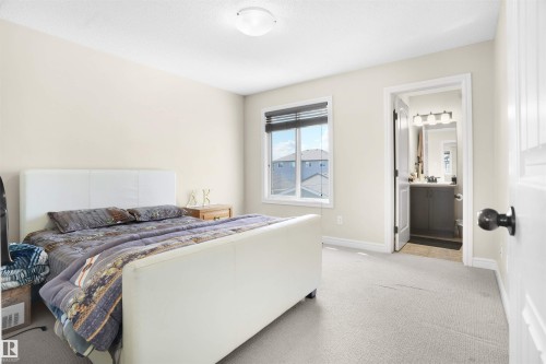 Bedroom featuring light carpet and connected bathroom - 1442 33A Street Nw, Edmonton, AB - Indoor Photo Showing Bedroom