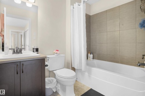 Full bathroom featuring vanity, shower / bath combo, and light tile patterned flooring - 1442 33A Street Nw, Edmonton, AB - Indoor Photo Showing Bathroom