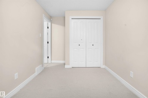 Unfurnished bedroom featuring light carpet and a closet - 1442 33A Street Nw, Edmonton, AB - Indoor Photo Showing Other Room