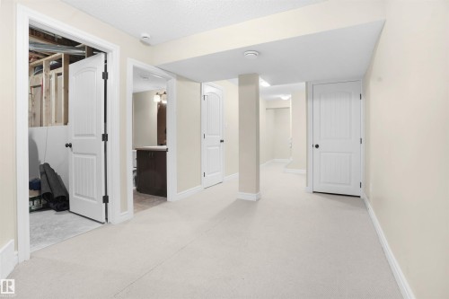 Hall featuring light colored carpet and a textured ceiling - 1442 33A Street Nw, Edmonton, AB - Indoor Photo Showing Other Room