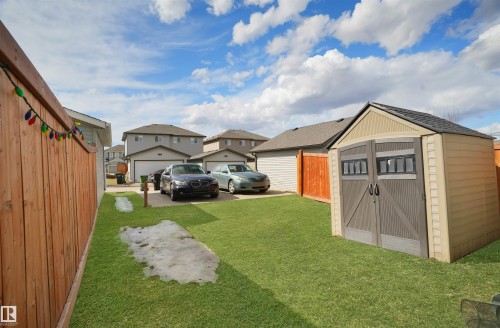 View of grassy yard with a storage shed and a residential view - 1442 33A Street Nw, Edmonton, AB - Outdoor
