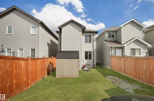 Rear view of house with a shed, roof with shingles, a fenced backyard, and a residential view - 1442 33A Street Nw, Edmonton, AB - Outdoor