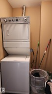 Washroom featuring stacked washing machine and dryer and a textured ceiling - 