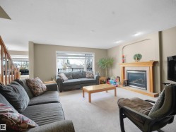Living area featuring a glass covered fireplace and carpet - 