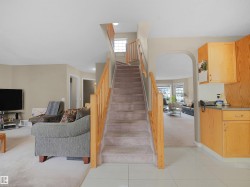 Stairway featuring carpet floors, tile patterned floors, and arched walkways - 