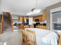 Dining area featuring stairs, arched walkways, and light tile patterned floors - 