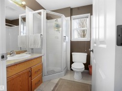 Full bathroom featuring a stall shower, vanity, and light tile patterned floors - 