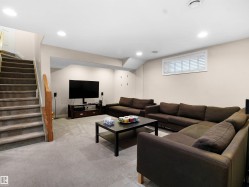 Living room with light colored carpet, recessed lighting, and stairway - 