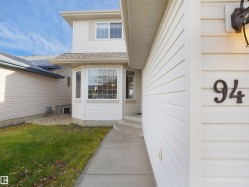 Entrance to property featuring a yard and a shingled roof - 