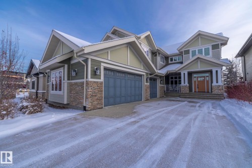 Craftsman-style house with stone siding, driveway, and an attached garage - 7549 May Common, Edmonton, AB - Outdoor With Facade