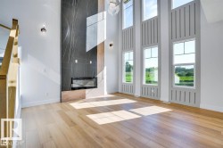Unfurnished living room featuring light wood-style flooring, healthy amount of natural light, and a high ceiling - 