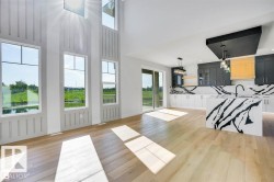 Living room featuring a water view and light wood-style flooring - 
