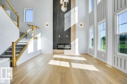 Foyer entrance featuring plenty of natural light, stairway, hardwood / wood-style flooring, and a towering ceiling - 