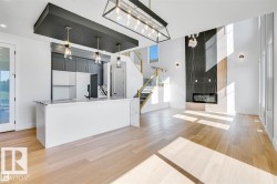 Kitchen featuring hanging light fixtures, light wood finished floors, open floor plan, and gray cabinets - 