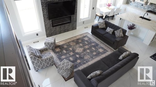 Living area featuring light tile patterned flooring and a premium fireplace - 707 180 Street, Edmonton, AB - Indoor With Fireplace