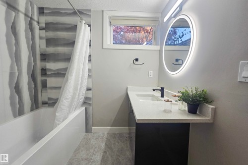 Full bathroom with shower / bath combination with curtain, vanity, and a textured ceiling - 4203 83 Street, Edmonton, AB - Indoor Photo Showing Bathroom