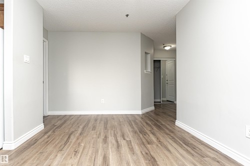 Unfurnished room with light wood finished floors and a textured ceiling - 108 2305 35A Avenue, Edmonton, AB - Indoor Photo Showing Other Room