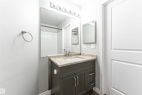 Bathroom with vanity, a shower, and dark wood-type flooring - 108 2305 35A Avenue, Edmonton, AB - Indoor Photo Showing Bathroom