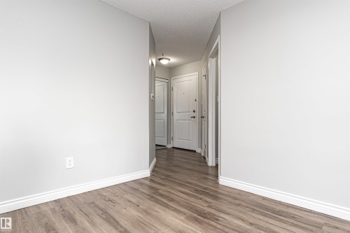 Hallway featuring a textured ceiling and wood finished floors - 108 2305 35A Avenue, Edmonton, AB - Indoor Photo Showing Other Room