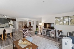 Living area featuring dark wood-style flooring and a chandelier - 
