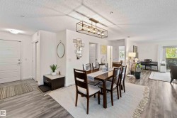 Dining area featuring dark wood-style floors, a textured ceiling, healthy amount of natural light, and a baseboard heating unit - 