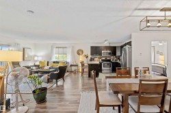 Dining area featuring light wood-type flooring, a textured ceiling, and a ceiling fan - 