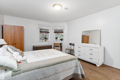 Bedroom featuring wood finished floors and a textured ceiling - 209 10915 21 Avenue, Edmonton, AB 