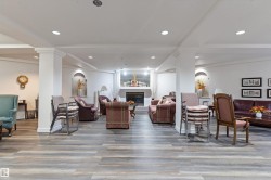 Living room featuring a tile fireplace, decorative columns, light wood-style flooring, and recessed lighting - 
