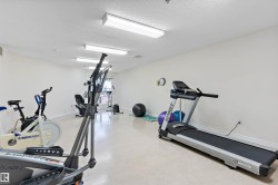 Exercise area featuring a textured ceiling and baseboards - 