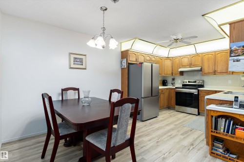 Kitchen featuring light countertops, stainless steel appliances, decorative light fixtures, decorative backsplash, and light wood-style flooring - 209 10915 21 Avenue, Edmonton, AB 