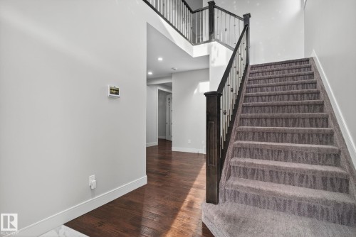 Stairs with hardwood / wood-style flooring, a towering ceiling, and recessed lighting - 8536 19 Avenue, Edmonton, AB - Indoor Photo Showing Other Room