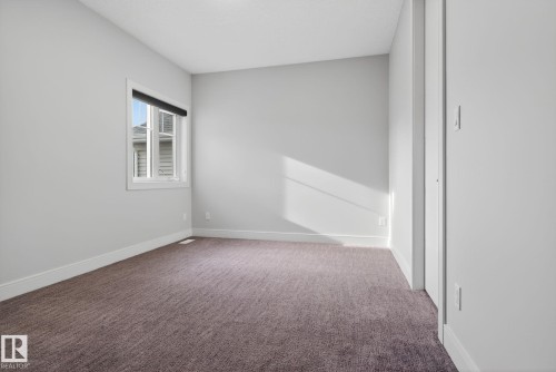 Empty room featuring dark carpet and baseboards - 8536 19 Avenue, Edmonton, AB - Indoor Photo Showing Other Room