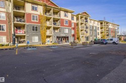 View of apartment building / complex featuring uncovered parking - 