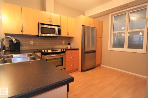 200 9940 Sherridon Drive, Fort Saskatchewan, AB - Indoor Photo Showing Kitchen With Stainless Steel Kitchen With Double Sink