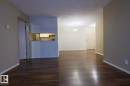 Unfurnished living room featuring dark wood-style flooring and a textured ceiling - 213 5065 31 Avenue, Edmonton, AB  - Indoor Photo Showing Other Room 