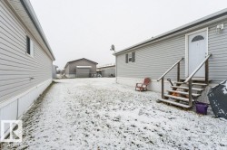 Yard layered in snow featuring a detached garage and entry steps - 