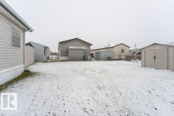 Snowy yard featuring a storage unit and a garage - 