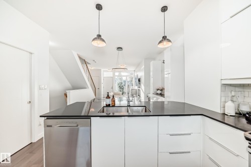 Kitchen with white cabinetry, modern cabinets, dishwasher, and dark wood-style flooring - 14812 98 Avenue, Edmonton, AB - Indoor Photo Showing Kitchen With Double Sink With Upgraded Kitchen