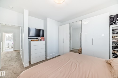 Bedroom with light colored carpet and two closets - 14812 98 Avenue, Edmonton, AB - Indoor Photo Showing Bedroom