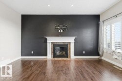 Unfurnished living room featuring hardwood / wood-style flooring, a tile fireplace, and a textured ceiling - 
