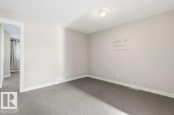 Carpeted empty room with a textured ceiling and baseboards - 