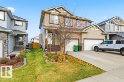 Craftsman-style house with a front yard, driveway, and a garage - 
