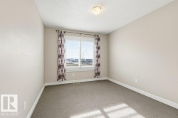 Carpeted spare room featuring a textured ceiling and baseboards - 