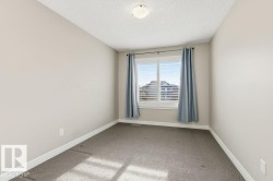 Spare room featuring light colored carpet and a textured ceiling - 