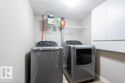 Laundry area with a textured ceiling and washer and dryer - 