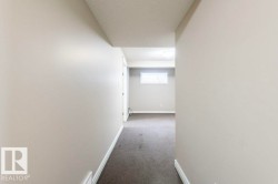 Hallway featuring carpet floors and a textured ceiling - 