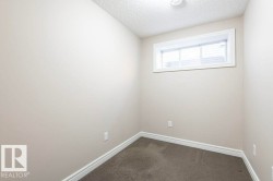 Spare room featuring dark colored carpet and a textured ceiling - 