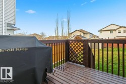 Wooden deck featuring a residential view, a yard, and grilling area - 