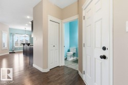 Hallway featuring dark wood-type flooring, a chandelier, a textured ceiling, and recessed lighting - 